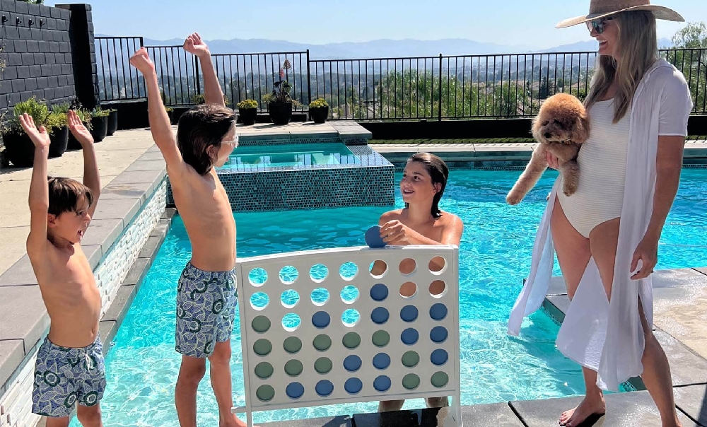 Family-friendly pool deck featuring a giant Connect Four game by Ledge Lounger, creating interactive entertainment for resort and hotel guests.